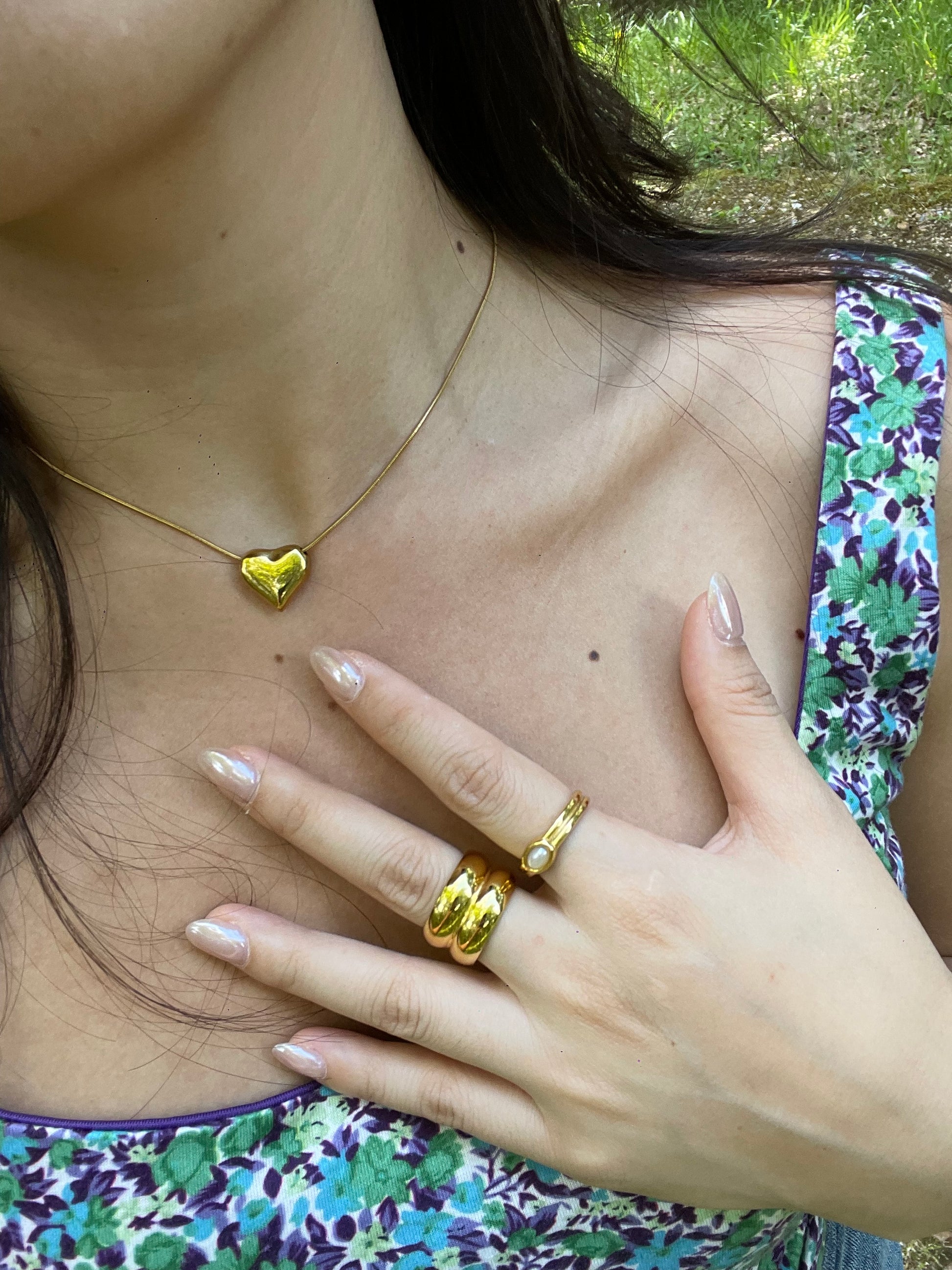 Model in bougainva gold plated rings and heart shape necklace